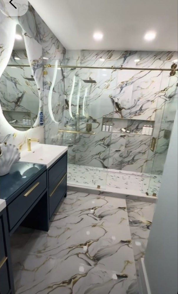 Mermer desenli banyo yenileme işi: camlı duş bölümü ve lacivert tezgah altı dolap